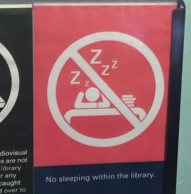 Il cartello "Non dormite in biblioteca" a Singapore